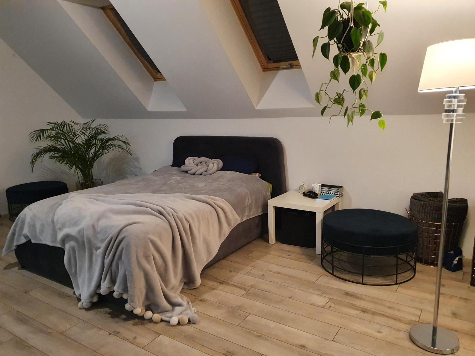 Ciemno szare łóżko z tapicerowanym zagłówkiem